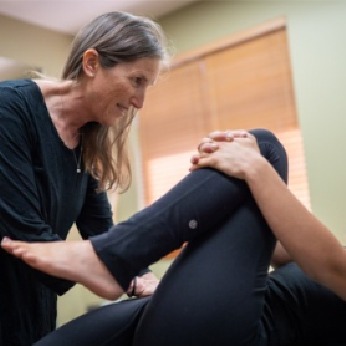 A patient stretching their leg during Holistic Pelvic Care